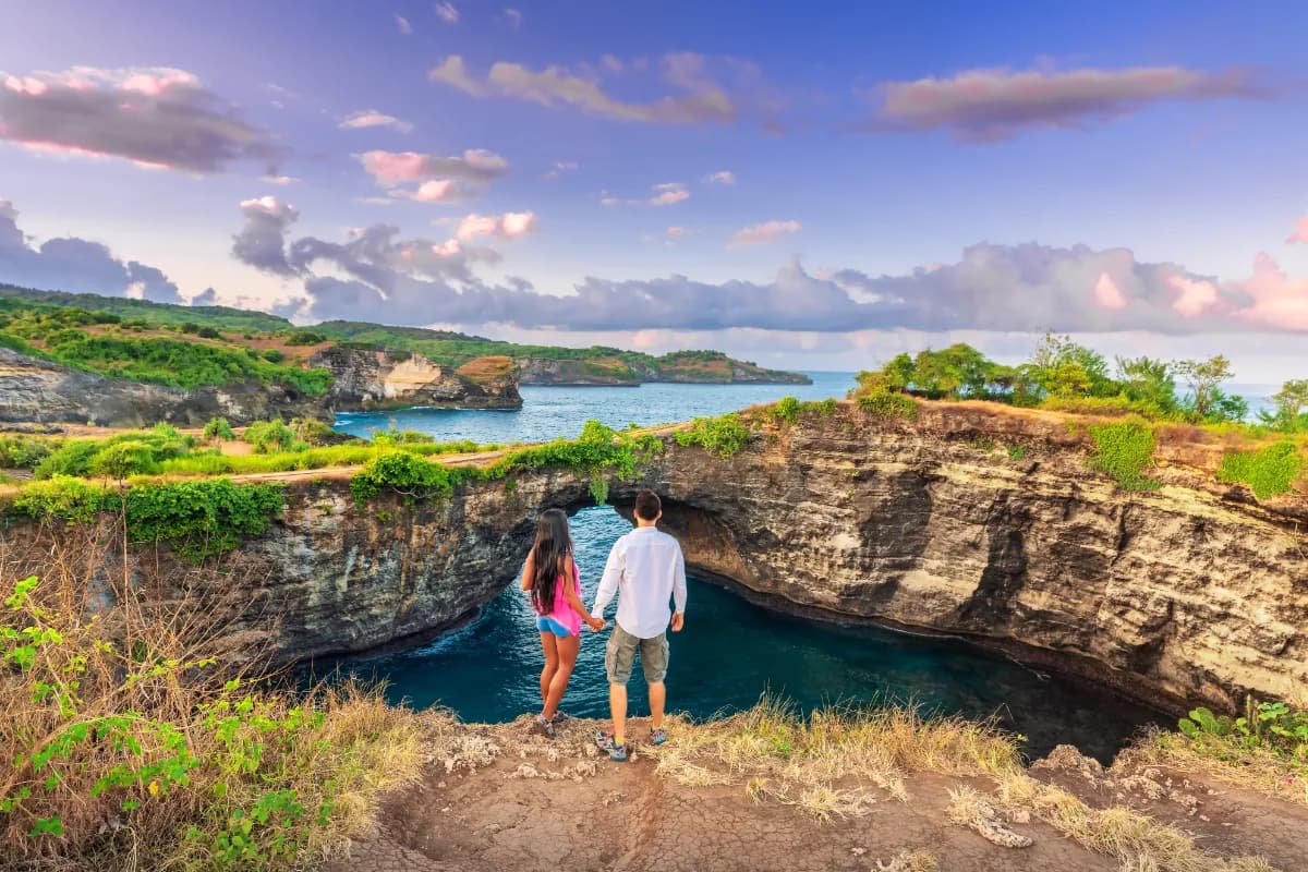 Travelers enjoying beautiful tropical beach Broken Beach in Nusa Penida